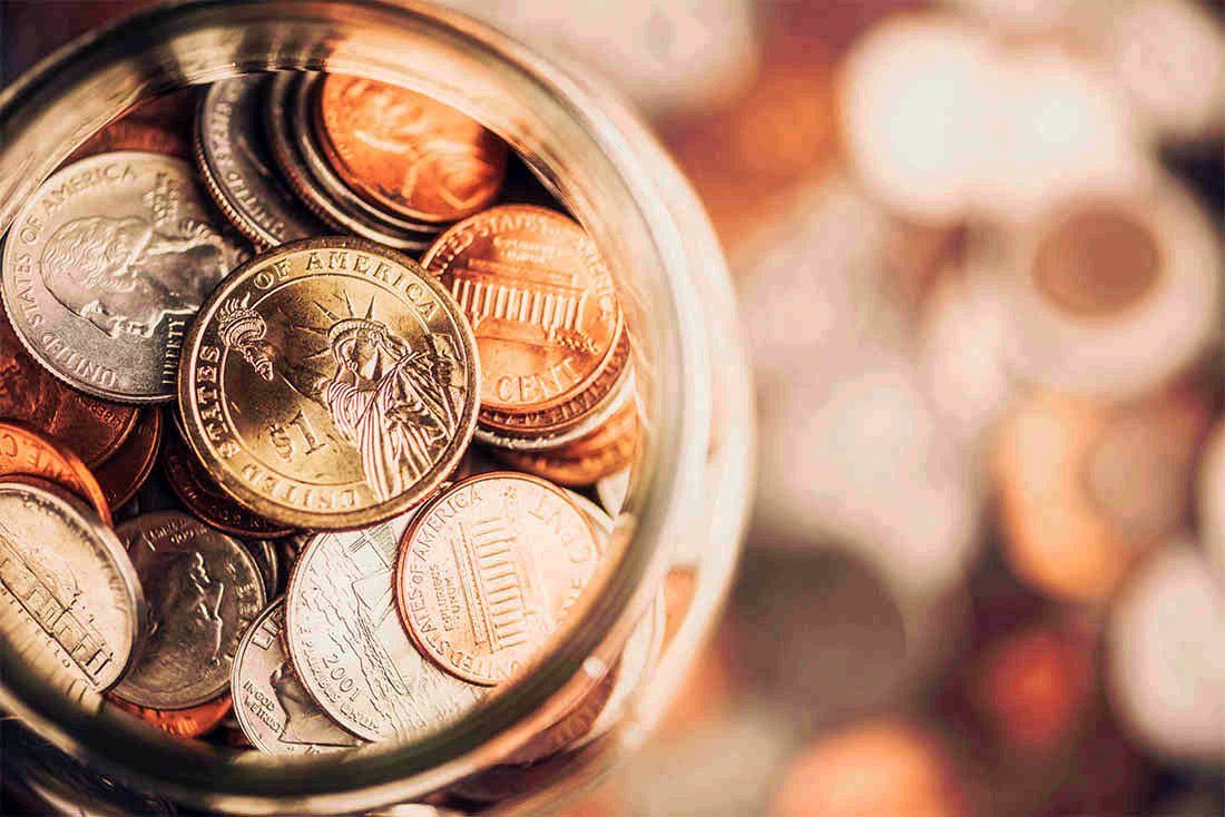 Glass jar filled with coins, seen from above