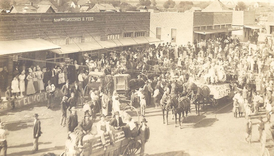 Trade Day crowd with horse-drawn wagons on the street in early Elmore City